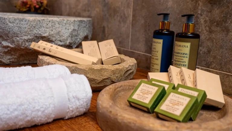 Primer plano de los amenities ecológicos premium colocados sobre jaboneras de piedra en el baño de un hotel de lujo en Áncash.