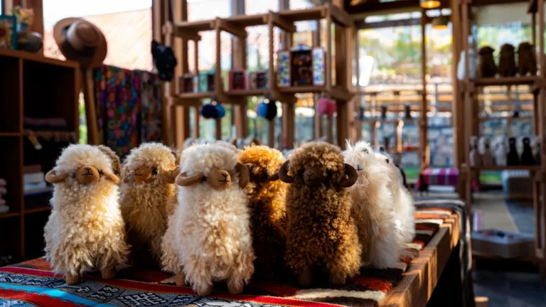 Peluches artesanales elaborados con fina fibra de alpaca, exhibidos sobre un telar tradicional en la boutique de diseño de Hotel Viscas, Áncash.